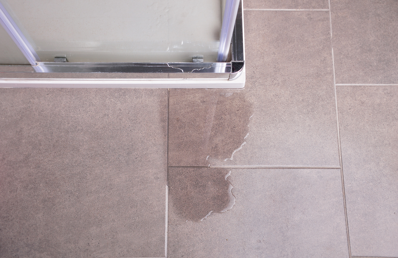 Leakage of water from a shower cabin with glass wall that is damaged